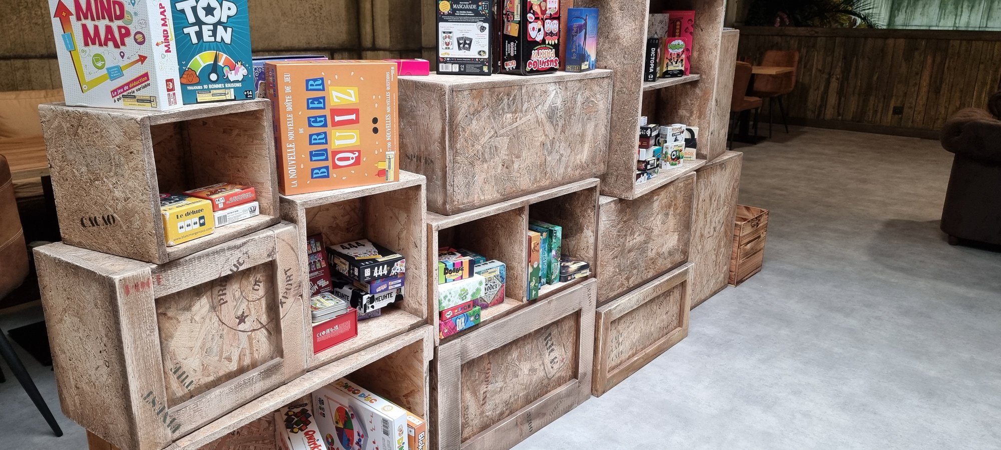 Les caisses de jeux de société mises en rayon dans le décor