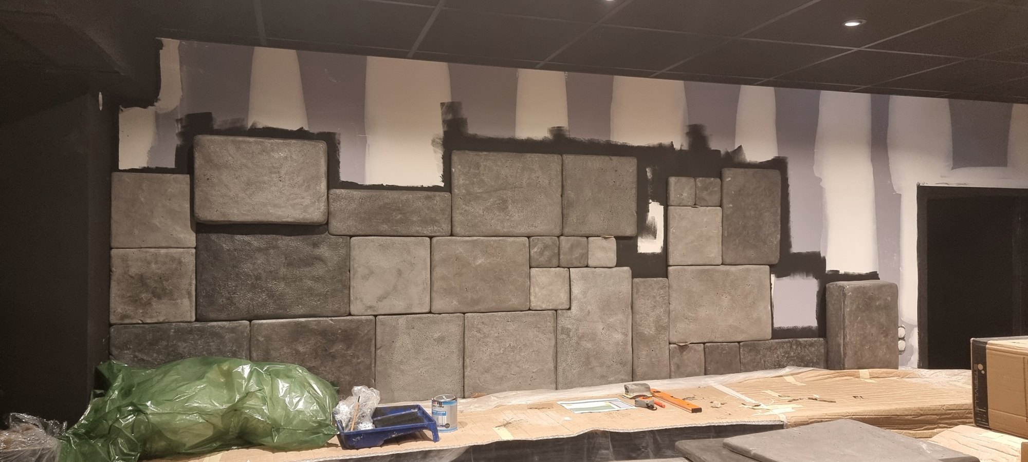 Les premières pierres moulées posées sur le mur