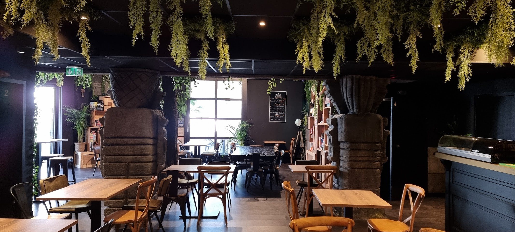Le bar du Temple et sa salle, colonnes de pierre et végétation suspendue