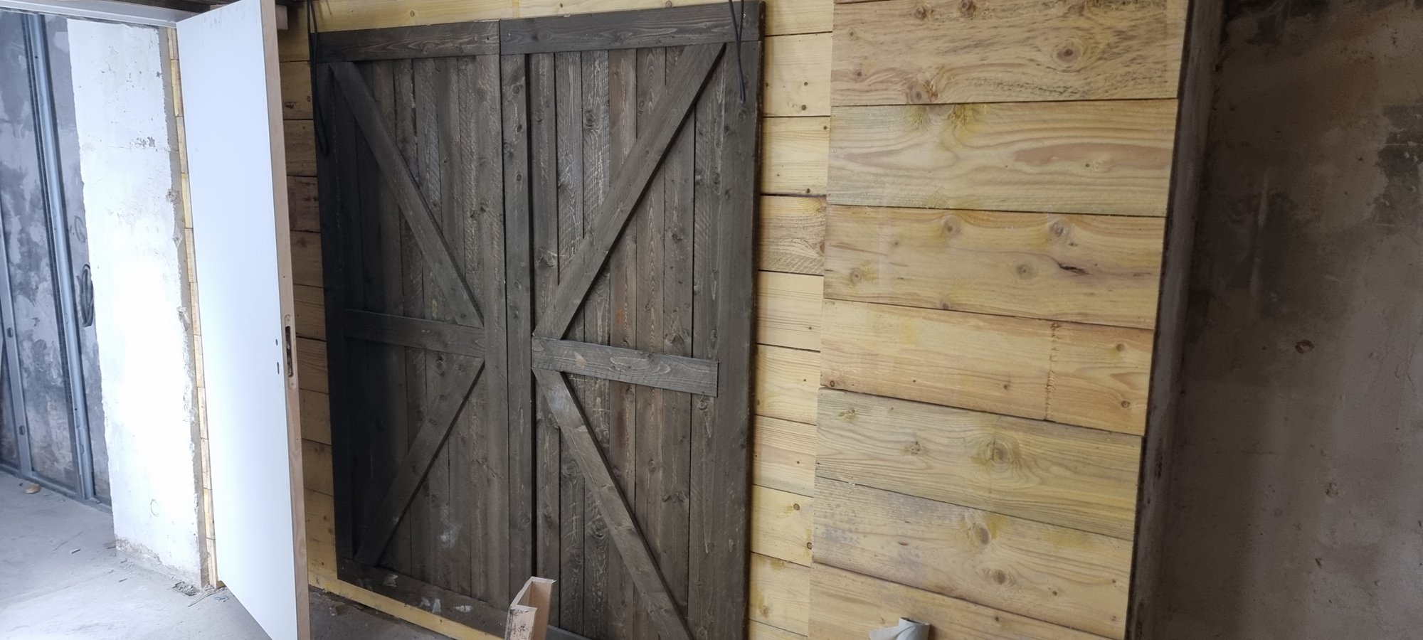 Une porte de bois posée sur le bardage