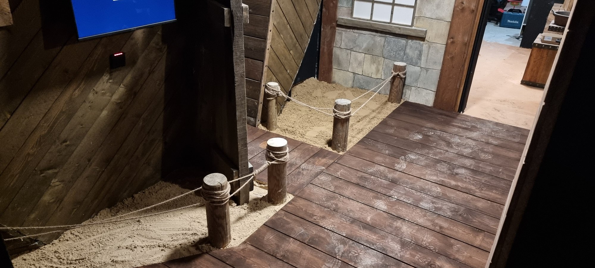 Une salle habillée de bois, écran de jeu intégré au décor
